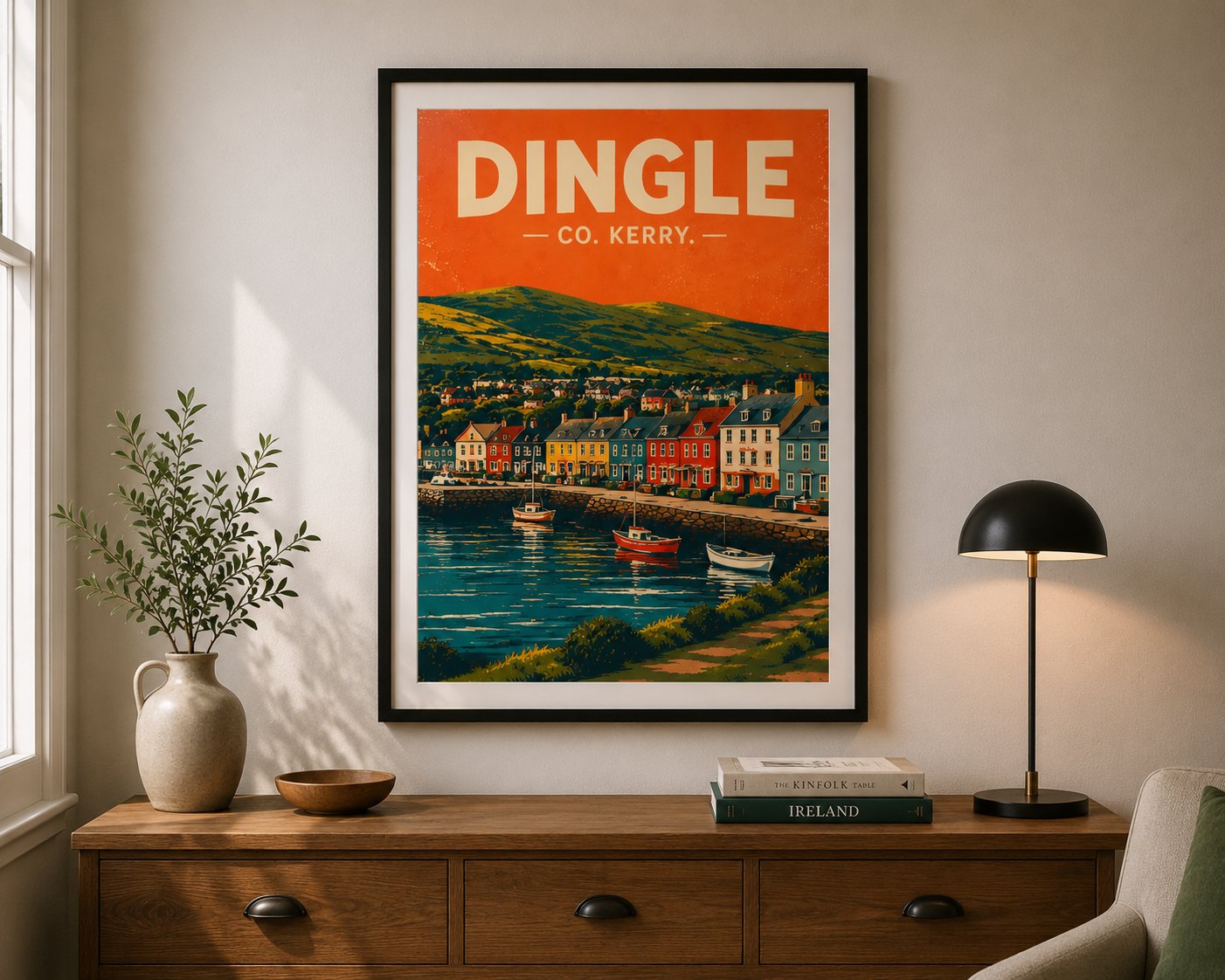 A framed Dingle, Co. Kerry travel-poster print by Ardfert Printing, styled on a wall above a wooden sideboard in a bright living room